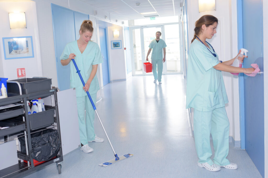Krankenhauspersonal reinigt Flur und Tür im Krankenhaus